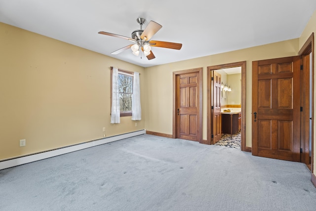 unfurnished bedroom with ensuite bathroom, a baseboard radiator, a ceiling fan, baseboards, and carpet