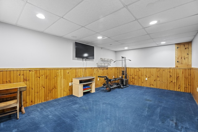 workout area featuring a drop ceiling, wainscoting, carpet flooring, wood walls, and recessed lighting