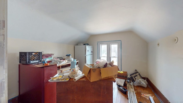 additional living space with baseboards, vaulted ceiling, and hardwood / wood-style floors