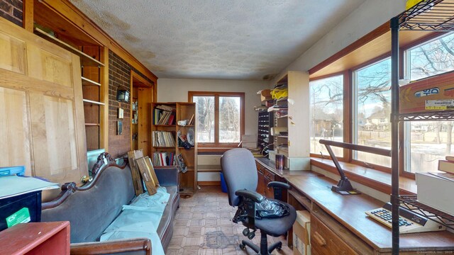 office with built in desk, a textured ceiling, and tile patterned floors