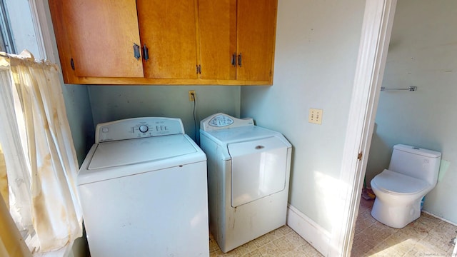 laundry area with washer and dryer, cabinet space, and light floors