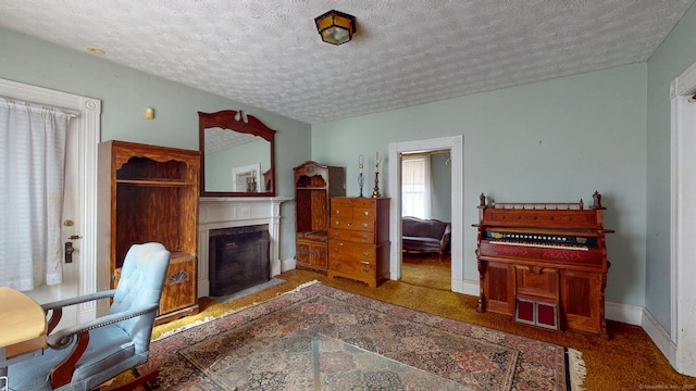 carpeted office space with a textured ceiling, a fireplace, and baseboards