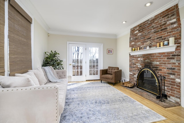 living room featuring crown molding, recessed lighting, a fireplace, and wood finished floors