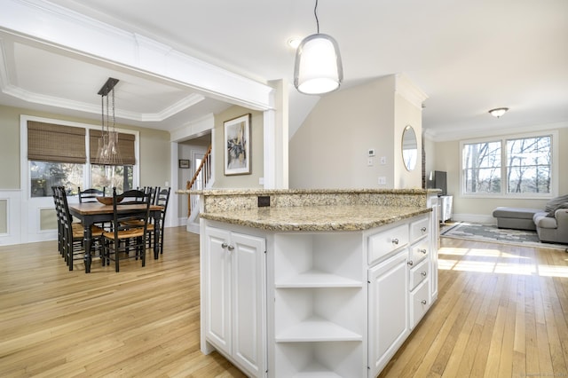 kitchen with open floor plan, open shelves, light wood-style flooring, and light stone countertops