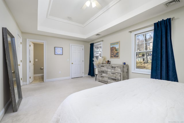 bedroom featuring baseboards, visible vents, a tray ceiling, and light colored carpet