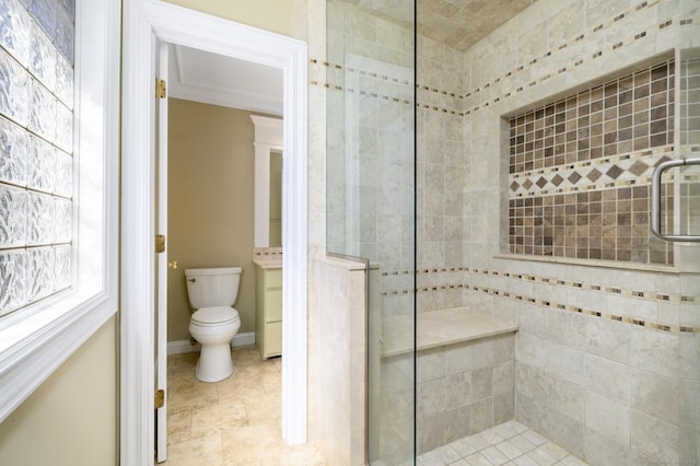 bathroom featuring baseboards, tiled shower, and toilet