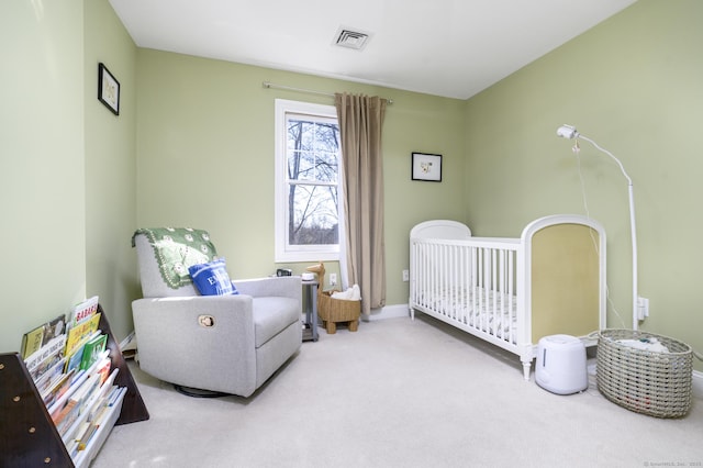 carpeted bedroom with a nursery area, visible vents, and baseboards