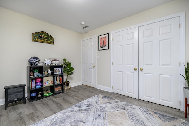 interior space with visible vents, baseboards, and wood finished floors