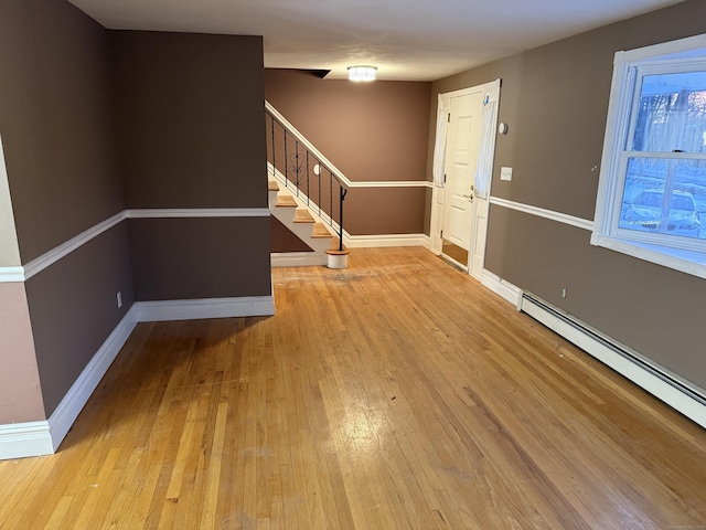 interior space featuring hardwood / wood-style flooring, baseboards, stairway, and a baseboard heating unit