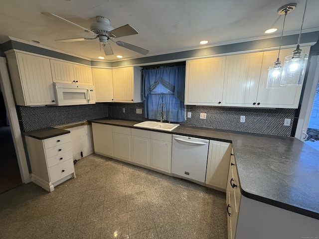 kitchen featuring dark countertops, white appliances, granite finish floor, and a sink