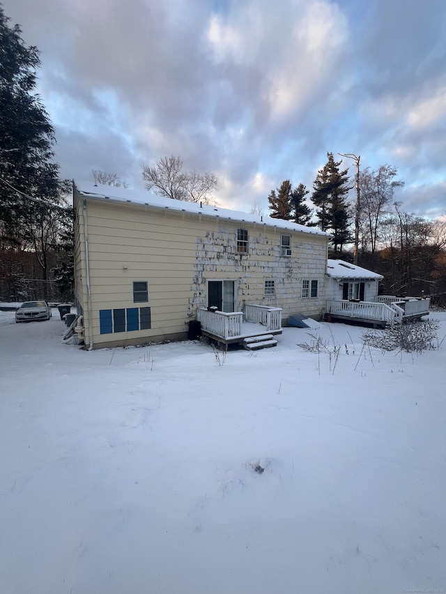 snow covered property featuring a wooden deck