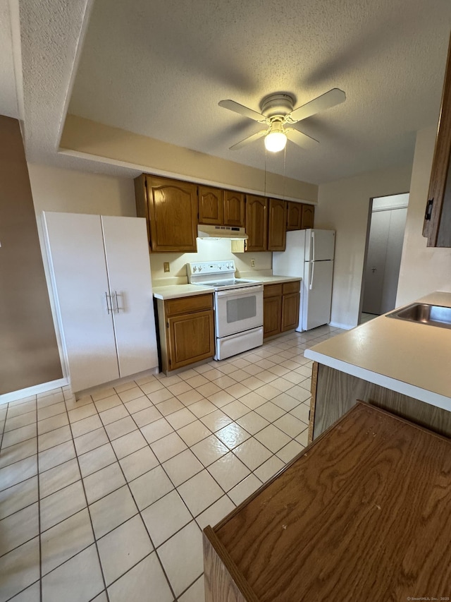 kitchen with ceiling fan, under cabinet range hood, white appliances, a sink, and light countertops