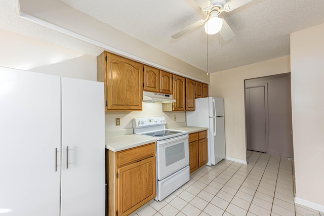 kitchen with white appliances, light countertops, under cabinet range hood, and a textured ceiling