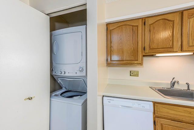 laundry area with stacked washer and dryer, laundry area, and a sink