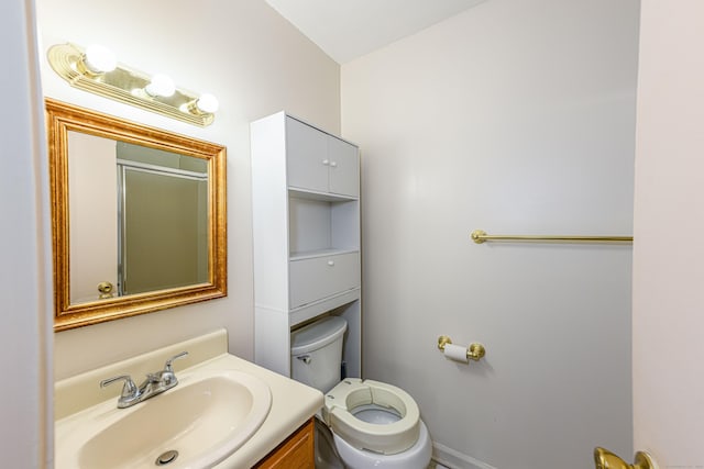 bathroom with vanity, toilet, and a shower with door