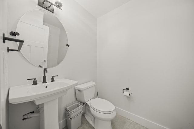 bathroom featuring toilet, tile patterned flooring, and baseboards