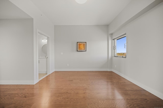 unfurnished room featuring baseboards and wood finished floors