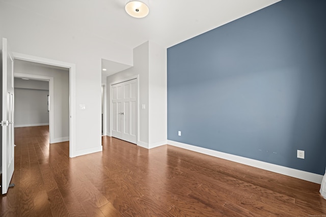 interior space with a closet, baseboards, and wood finished floors