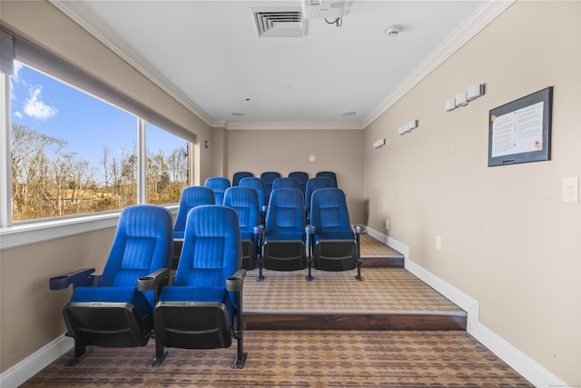 carpeted home theater room with baseboards, visible vents, and crown molding