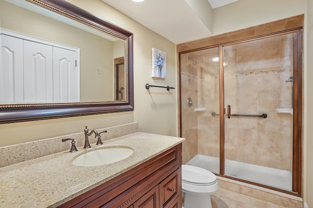 bathroom with a stall shower, vanity, and toilet