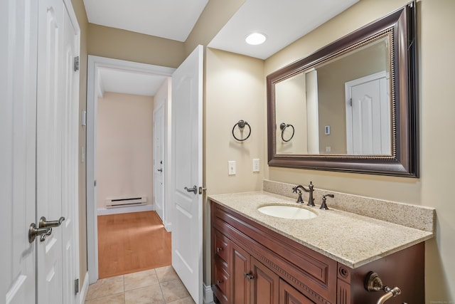 bathroom featuring a baseboard heating unit, tile patterned flooring, and vanity