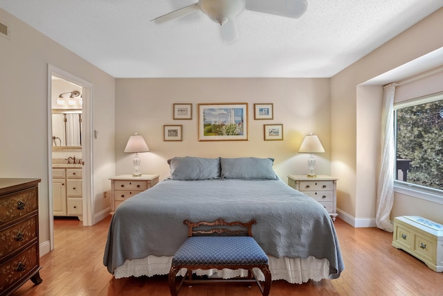 bedroom featuring visible vents, light wood-style flooring, a ceiling fan, a textured ceiling, and baseboards