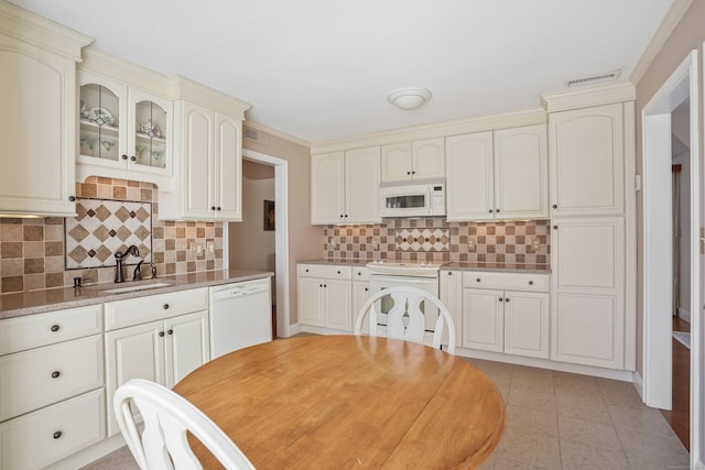 kitchen featuring white appliances, a sink, cream cabinets, and light tile patterned floors