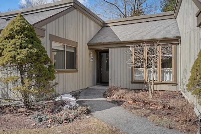 property entrance with a shingled roof and board and batten siding