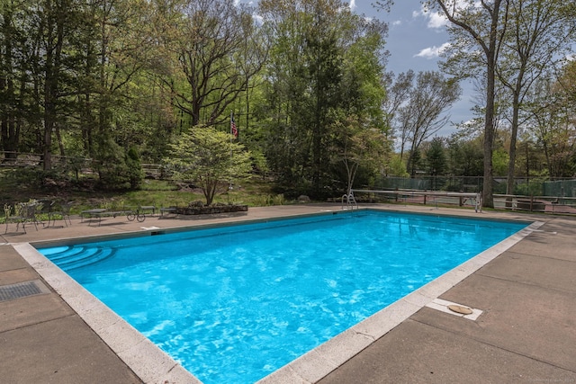 view of swimming pool with a patio area, fence, and a fenced in pool