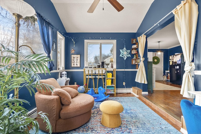 sitting room with lofted ceiling, wood finished floors, ceiling fan, and a baseboard radiator