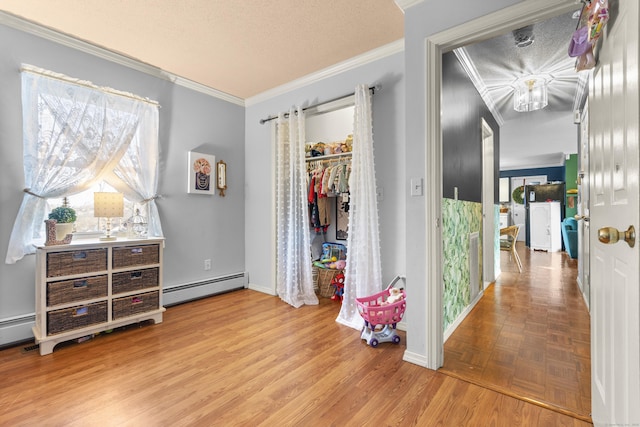 bedroom featuring ornamental molding, parquet floors, a textured ceiling, a baseboard heating unit, and a closet