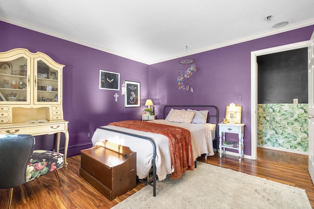 bedroom with ornamental molding, baseboard heating, baseboards, and wood finished floors