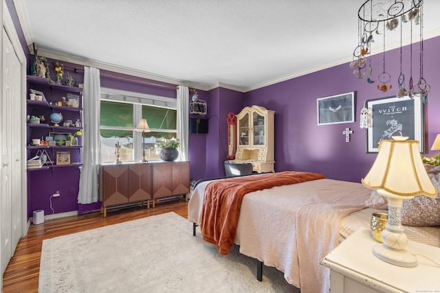 bedroom with crown molding, baseboards, and wood finished floors