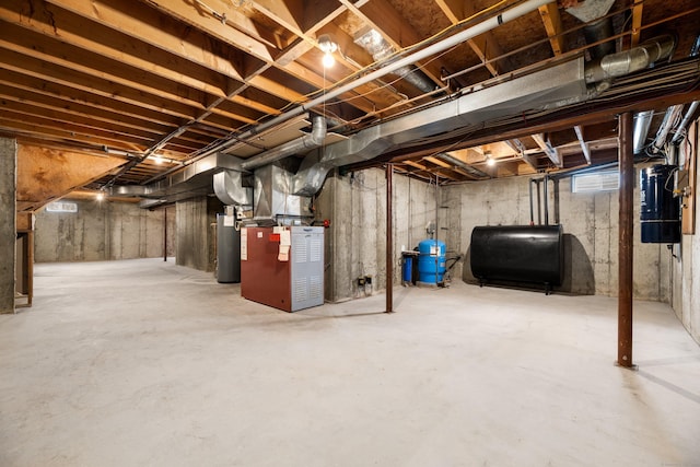 unfinished below grade area featuring water heater, heating unit, and heating fuel