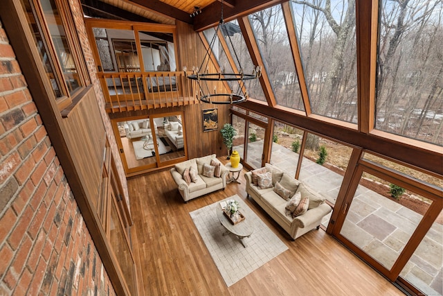 sunroom / solarium featuring vaulted ceiling with beams, an inviting chandelier, and wood ceiling