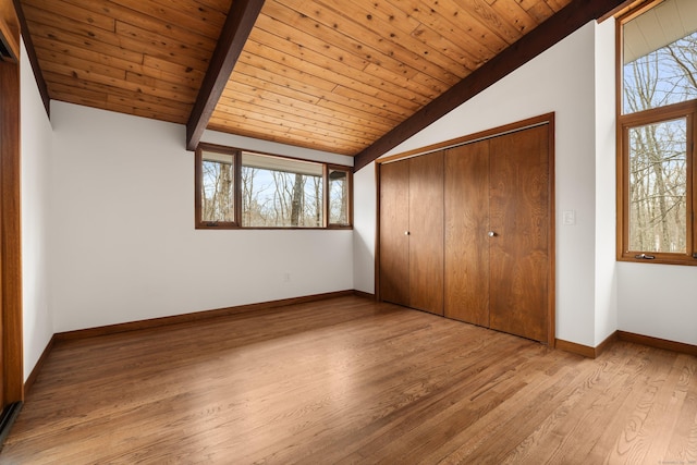 unfurnished bedroom featuring vaulted ceiling with beams, wooden ceiling, multiple windows, and wood finished floors