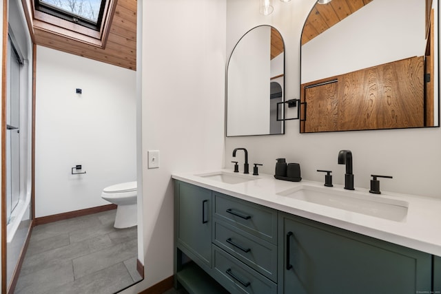 full bath featuring vaulted ceiling with skylight, wooden ceiling, a sink, and toilet