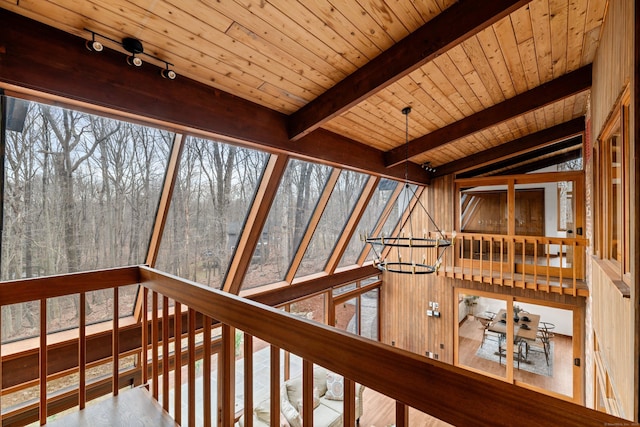 interior space with lofted ceiling with beams, wooden ceiling, and rail lighting