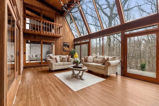 living area with wooden ceiling, a notable chandelier, wood finished floors, and beamed ceiling