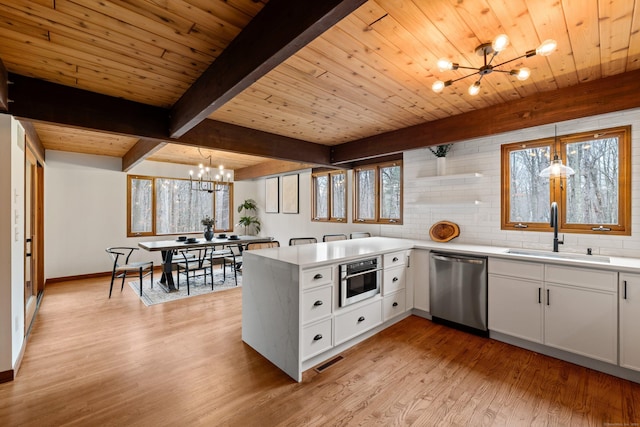 kitchen featuring a notable chandelier, stainless steel appliances, visible vents, light wood-style floors, and a sink