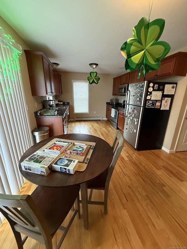 dining room featuring baseboards, a baseboard radiator, and light wood-style floors