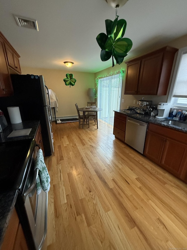 kitchen with dark countertops, visible vents, stove, a sink, and dishwasher