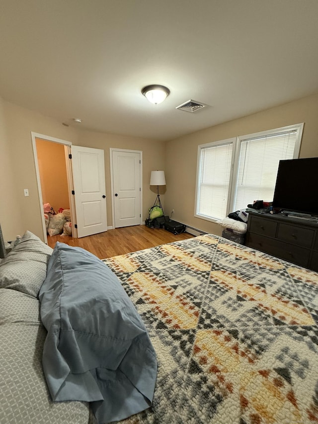 bedroom with wood finished floors and visible vents