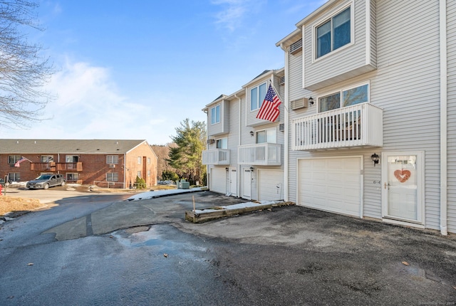 exterior space with driveway, an attached garage, and a residential view