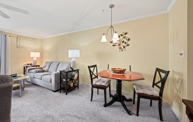 dining space with carpet floors, baseboards, crown molding, and ceiling fan with notable chandelier