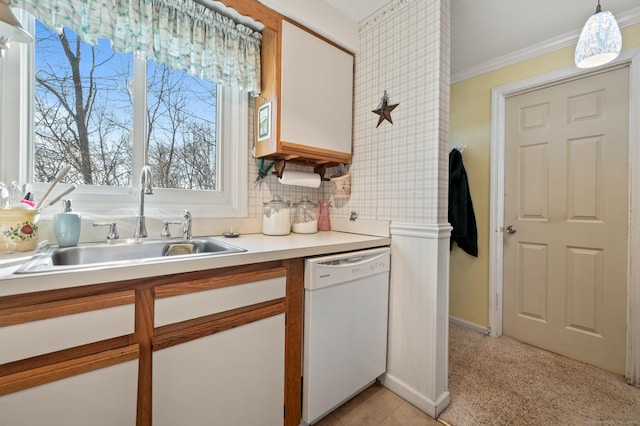 kitchen with white dishwasher, a sink, light countertops, ornamental molding, and hanging light fixtures