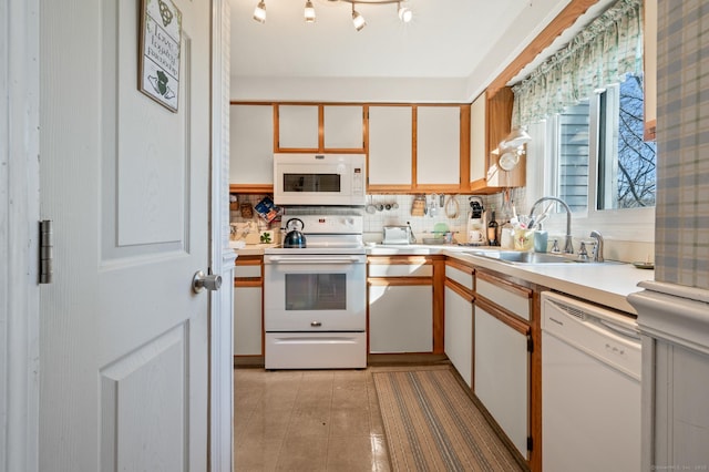 kitchen featuring white appliances, a sink, light countertops, backsplash, and light tile patterned flooring