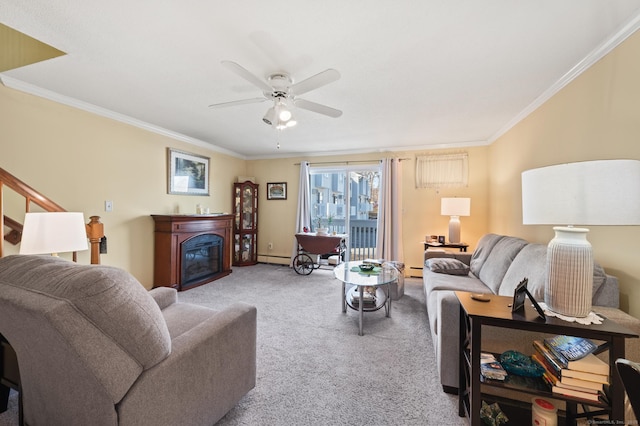 living area featuring a ceiling fan, a glass covered fireplace, a baseboard radiator, crown molding, and carpet flooring