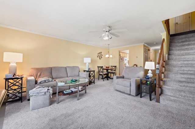 carpeted living area with ornamental molding, ceiling fan, and stairway