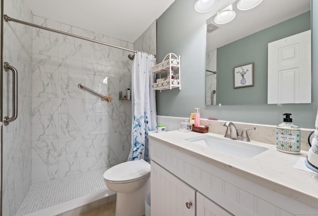 full bath with a stall shower, visible vents, wainscoting, toilet, and vanity